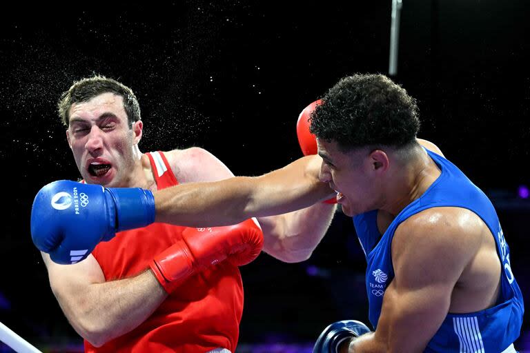 Davit Chaloyan de Armenia (en rojo) recibe un puñetazo del británico Delicious Orie en la ronda preliminar masculina de +92 kg de boxeo