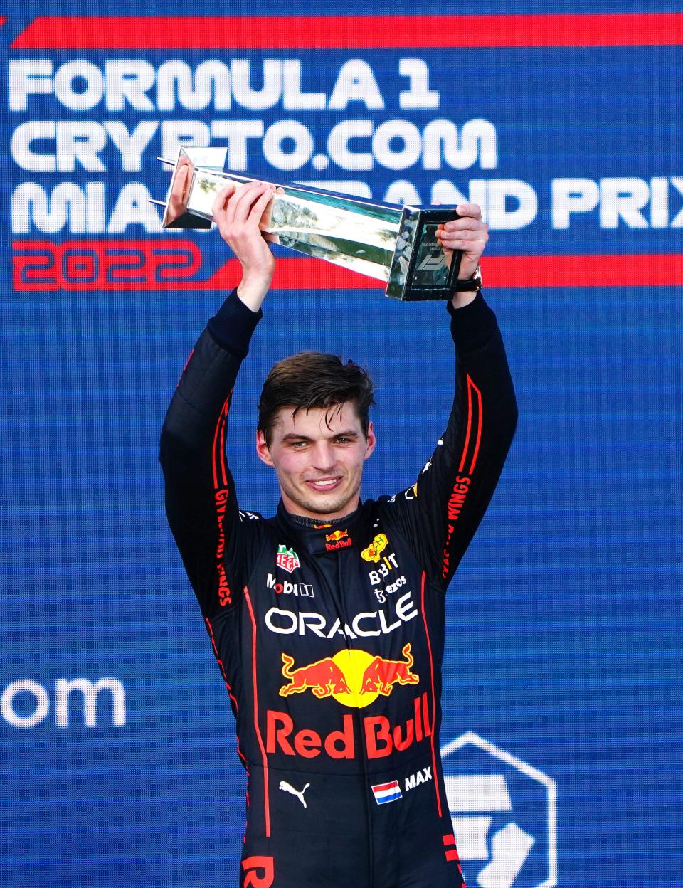 May 8, 2022; Miami Gardens, Florida, USA; Red Bull driver Max Verstappen of the Netherlands is presented with his trophy by Dan Marino on the podium after winning the Miami Grand Prix at Miami International Autodrome.