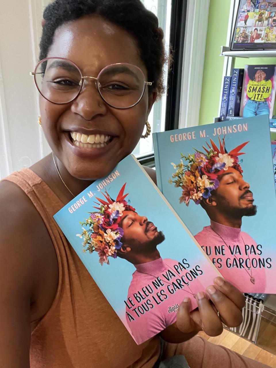 A selfie of Patrice Caldwell, holding up a book