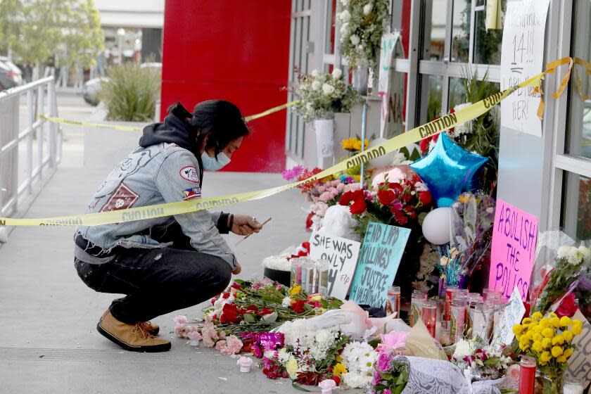 NORTH HOLLYWOOD, CA - DECEMBER 28: A man places incense a memorial for Valentina Orellana Peralta at the door of the Burlington Coat Factory. The League of United Latin American Citizens seeks answers in the killing of 14-year-old Valentina Orellana Peralta, requesting a full investigation and meeting with Los Angeles Police Chief Michel Moore and Mayor Eric Garcetti, in a press conference at the Burlington Coat Factory on Tuesday, Dec. 28, 2021 in North Hollywood, CA. The site where a 14-year-old girl was shot and killed when LAPD was trying to apprehend an individual inside the store. The suspect Daniel Elena-Lopez was killed, as was Valentina Orellana-Peralta, a 14-year-old trying on clothes in a dressing room nearby. (Gary Coronado / Los Angeles Times)