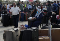 Passengers sit next to their luggage as they wait to cross the border to the Egyptian side of Rafah crossing, in Rafah, Gaza Strip, Tuesday, Aug. 11, 2020. Egypt reopened Rafah Crossing for three days starting Tuesday for humanitarian cases in and out of the Gaza Strip, including medical patients and people who had Egyptian and international citizenship. The border was closed since March. (AP Photo/Adel Hana)