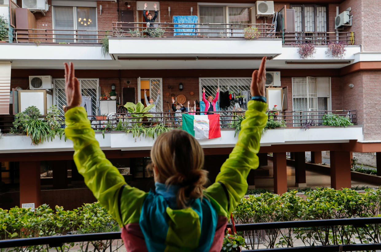 Personal trainer Antonietta Orsini carries out an exercise class for her neighbours from her balcony while Italians cannot leave their homes due to the coronavirus disease (COVID-19) outbreak, in Rome, Italy, March 18, 2020. Picture taken March 18, 2020 REUTERS/Remo Casilli