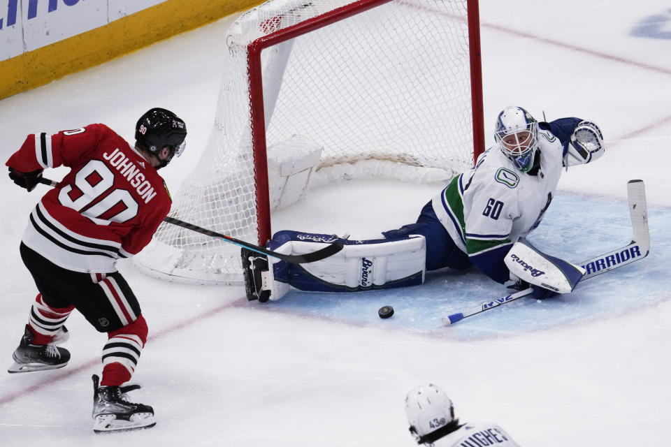 Vancouver Canucks goaltender Collin Delia, right, saves a shot by Chicago Blackhawks center Tyler Johnson during the third period of an NHL hockey game in Chicago, Sunday, March 26, 2023. (AP Photo/Nam Y. Huh)