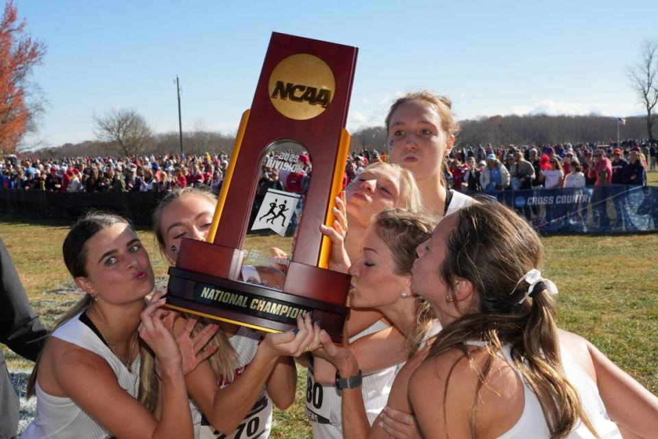 Members of the NC State Wolfpack women’s team kiss the championship trophy after winning the team title during the NCAA cross country championships at Panorama Farms. Mandatory Credit: Kirby Lee-USA TODAY Sports
