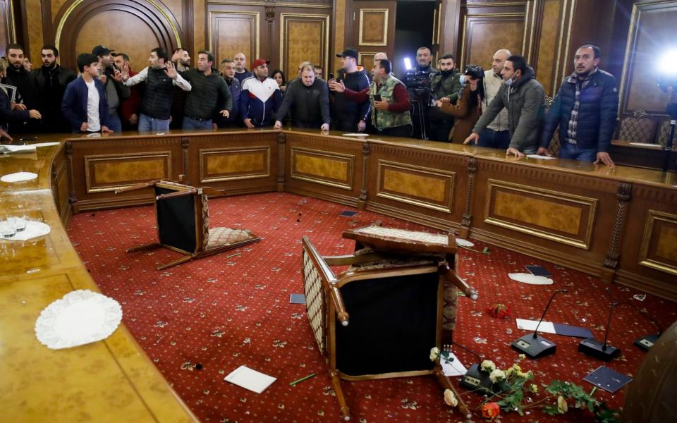 People protest against an agreement to halt fighting over the Nagorno-Karabakh region, inside the government building in Yerevan - AP