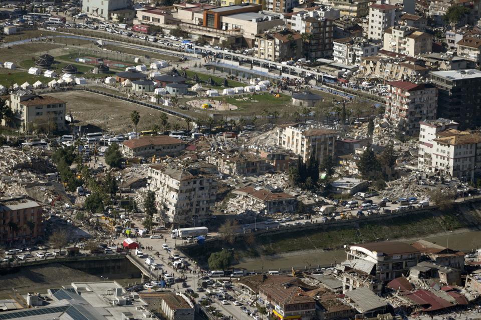 Collapsed buildings are seen in Antakya, southern Turkey, Wednesday, Feb. 8, 2023. Nearly two days after the magnitude 7.8 quake struck southeastern Turkey and northern Syria, thinly stretched rescue teams work to pull more people from the rubble of thousands of buildings. (AP Photo/Khalil Hamra)