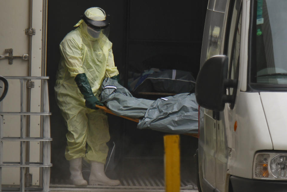 Health workers remove the body of a COVID-19 victim from a container, being used as a makeshift morgue, to turn over to a family outside the Joao Lucio public Hospital in Manaus, Amazonas state, Brazil, Monday, Jan. 4, 2021. (AP Photo/Edmar Barros)