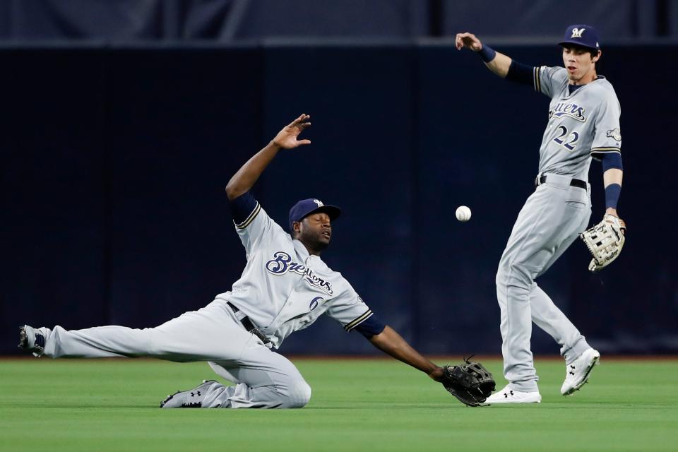 Milwaukee Brewers center fielder Lorenzo Cain (6) cannot reach a hit for a double by San Diego Padres' Hunter Renfroe as teammate right fielder Christian Yelich (22) looks on during the third inning of a baseball game Monday, June 17, 2019, in San Diego.