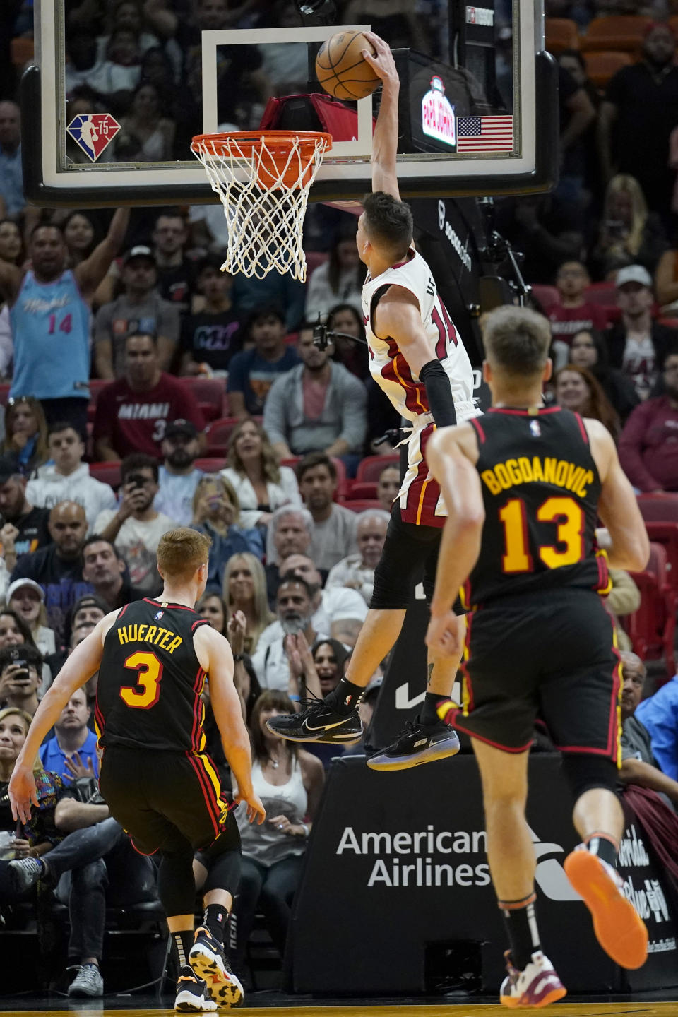 Miami Heat guard Tyler Herro dunks as Atlanta Hawks guard Kevin Huerter (3) and guard Bogdan Bogdanovic (13) watch during the first half of an NBA basketball game Friday, April 8, 2022, in Miami. (AP Photo/Lynne Sladky)