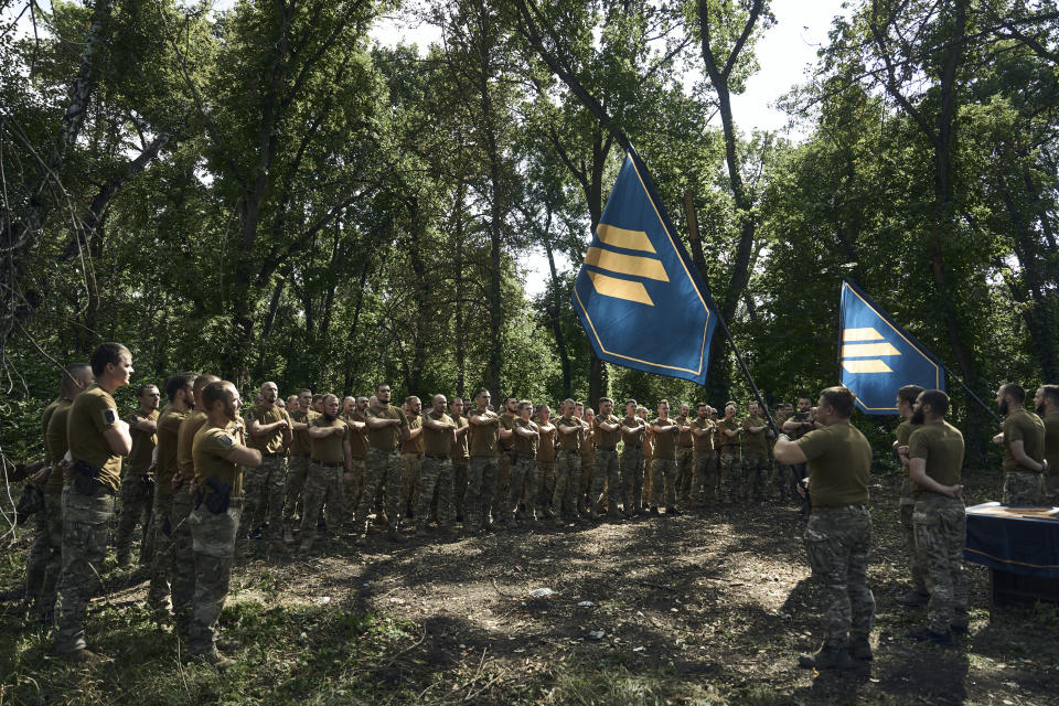 Soldiers of Ukraine's 3rd Separate Assault Brigade shout slogans as they stand in line, near Bakhmut, the site of fierce battles with the Russian forces in the Donetsk region, Ukraine, Sunday, Sept. 3, 2023. (AP Photo/Libkos)