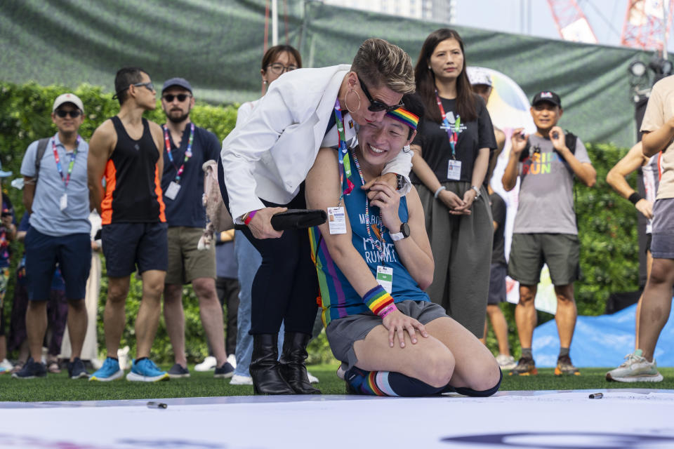 Participants react at the AIDS Quilt Memorial Ceremony, ahead of the Gay Games in Hong Kong, Saturday, Nov. 4, 2023. The first Gay Games in Asia are fostering hopes for wider LGBTQ+ inclusion in the regional financial hub, following recent court wins in favor of equality for same-sex couples and transgender people. (AP Photo/Chan Long Hei)