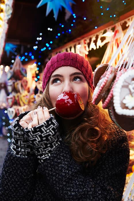 chica comiendo manzana dulce en Navidad