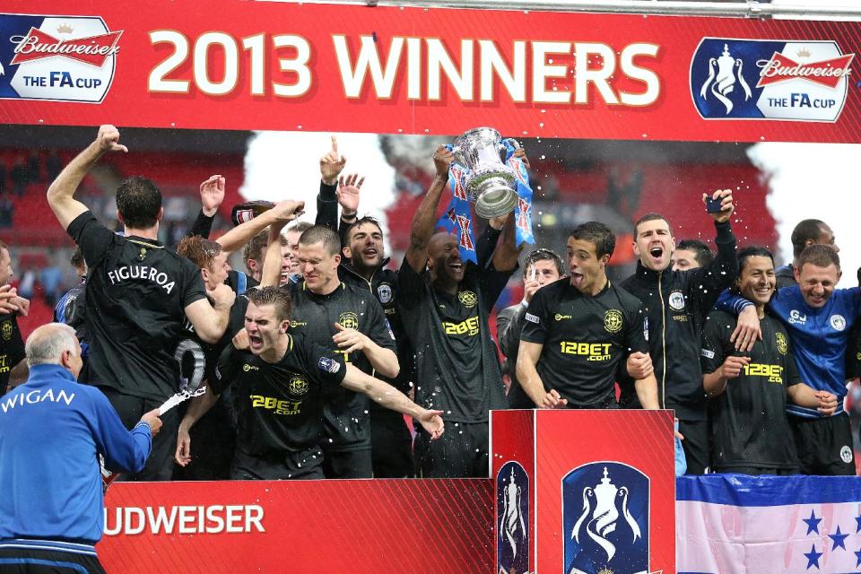 Wigan Athletic players celebrate their victory with the FA Cup trophy, after the final whistle