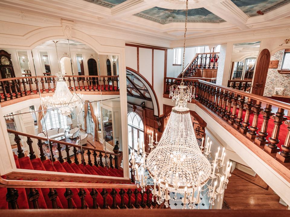 A view of the stairs and chandelier on the first floor of LeBlanc Castle.