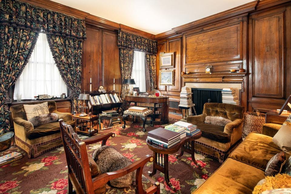7) The deep, wood-paneled library is filled with ornate detailing and vintage furniture.