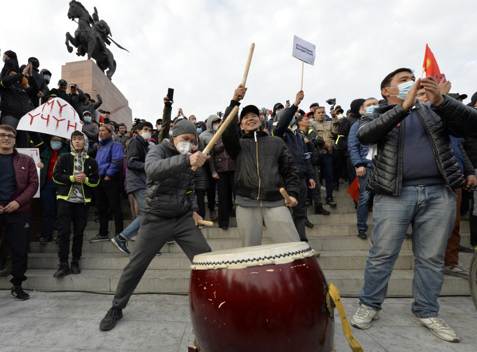 Supporters of former President Almazbek Atambayev bang on the drum during a rally on the central square in Bishkek, Kyrgyzstan, Friday, Oct. 9, 2020. Sooronbai Jeenbekov, the embattled president of Kyrgyzstan, has moved to end the political turmoil that followed a disputed parliamentary election, ordering a state of emergency in the capital. Jeenbekov has faced calls to resign by protesters who stormed government buildings after Sunday’s parliamentary vote was reportedly swept by pro-government parties. Protesters freed former President Almazbek Atambayev, who was jailed on charges seen by his supporters as a political vendetta. (AP Photo/Vladimir Voronin)