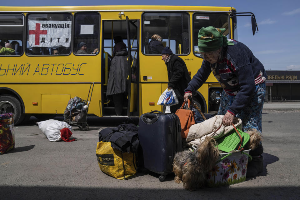 A woman from Siversk carries her belongings during an evacuation near Lyman, Ukraine, Wednesday, May 11, 2022. (AP Photo/Evgeniy Maloletka)