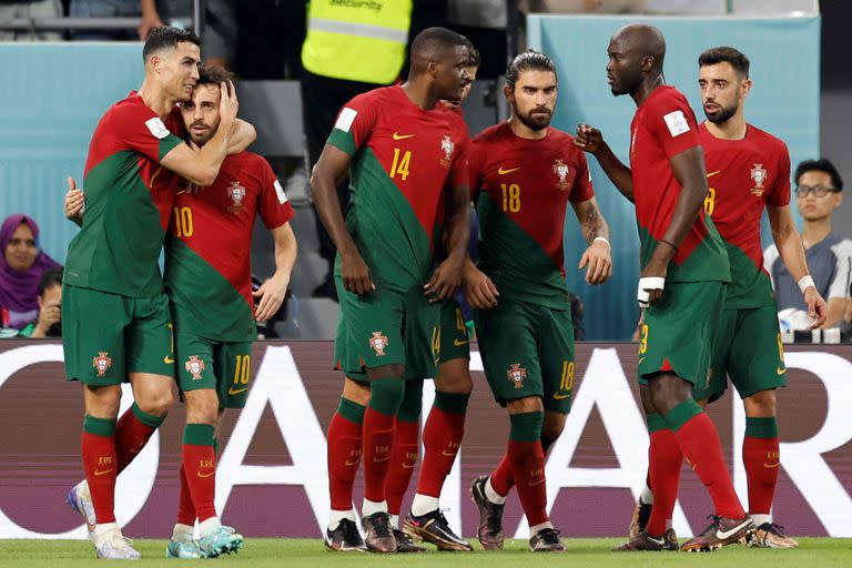 Portugal's forward #07 Cristiano Ronaldo (L) celebrates with Portugal's midfielder #10 Bernardo Silva (2nd L) after scoring his team's first goal from a penalty shot during the Qatar 2022 World Cup Group H football match between Portugal and Ghana at Stadium 974 in Doha on November 24, 2022. (Photo by Khaled DESOUKI / AFP)