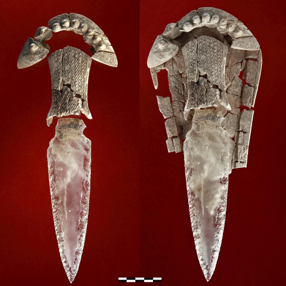 A knife with a clear crystal rock blade and a white ivory handle shaped like a row of teeth