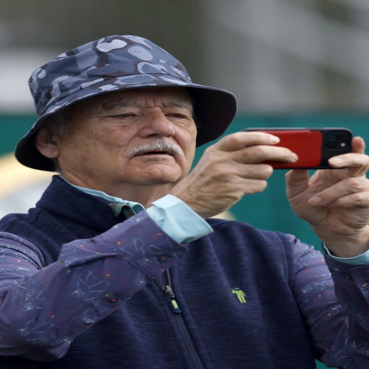 Closeup of Bill Murray taking a photo on his phone