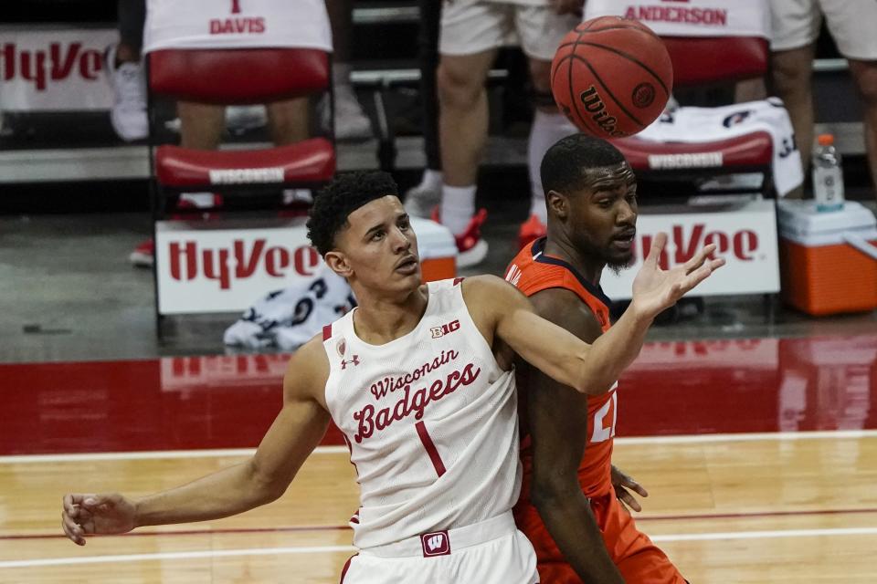 Wisconsin's Jonathan Davis and Illinois's Kofi Cockburn go after a loose ball during the first half of an NCAA college basketball game Saturday, Feb. 27, 2021, in Madison, Wis. (AP Photo/Morry Gash)