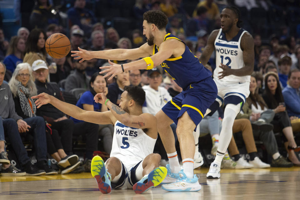 Minnesota Timberwolves forward Kyle Anderson (5) passes the ball to teammate Taurean Prince (12) around Golden State Warriors guard Klay Thompson (11 during the first quarter of an NBA basketball game, Sunday, March 26, 2023, in San Francisco. (AP Photo/D. Ross Cameron)