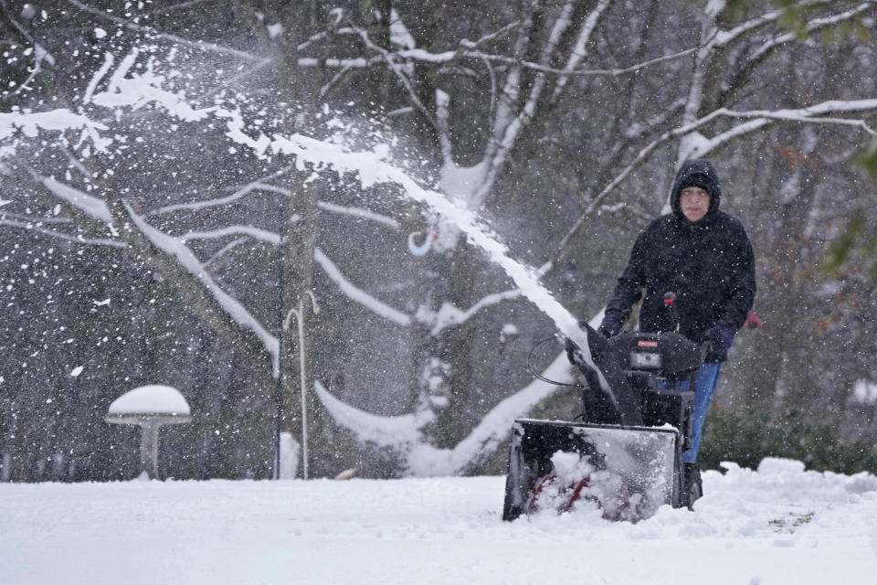 A man clears a driveway with a snowblower, Tuesday, Feb. 28, 2023, in Milton, N.H. Much of the area north of Boston received about two inches of snow before turning to rain from a winter storm. (AP Photo/Charles Krupa)