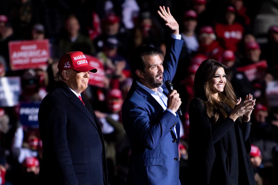 US President Donald Trump and Kimberly Guilfoyle listen while Donald Trump Jr. speaks during a Make America Great Again rally at Kenosha Regional Airport November 2, 2020, in Kenosha, Wisconsin.