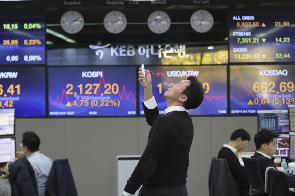 A currency trader uses a remote control to adjust temperature on an overhead air-conditioner at the foreign exchange dealing room of the KEB Hana Bank headquarters in Seoul, South Korea, Thursday, Nov. 14, 2019. Asian stock markets were mixed Thursday amid doubts about the status of a U.S.-Chinese trade deal after the U.S. Federal Reserve’s chairman said it is likely to leave its benchmark interest rate unchanged. (AP Photo/Ahn Young-joon)