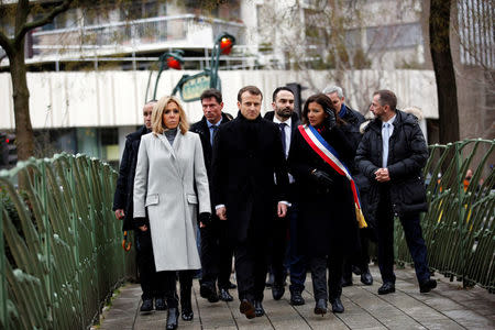 French President Emmanuel Macron his wife Brigitte and Paris mayor Anne Hidalgo arrive to observe a minute of silence in front of the plaque commemorating late police officer Ahmed Merabet to mark the third anniversary of the attack in Paris, France, January 7, 2018. REUTERS/Christophe Ena/Pool