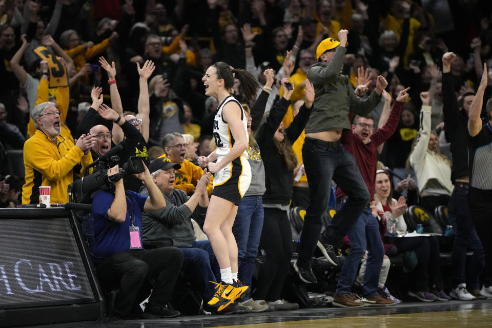 Iowa guard Caitlin Clark (22) reacts after breaking the NCAA women's career scoring record during the first half of the team's college basketball game against Michigan Thursday, Feb. 15, 2024, in Iowa City, Iowa. (AP Photo/Matthew Putney)