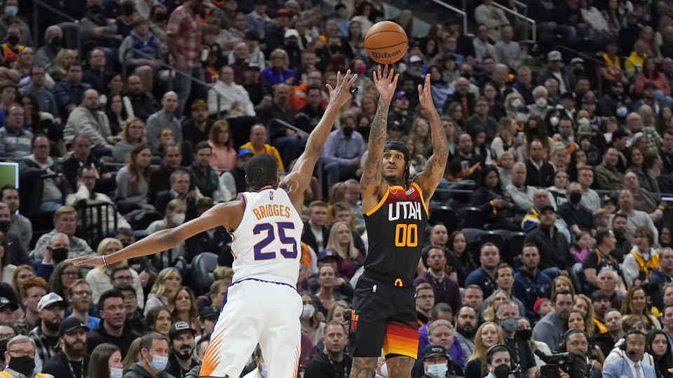 Utah Jazz guard Jordan Clarkson (00) shoots as Phoenix Suns forward Mikal Bridges (25) defends in the first half during an NBA basketball game Wednesday, Jan. 26, 2022, in Salt Lake City. (AP Photo/Rick Bowmer)