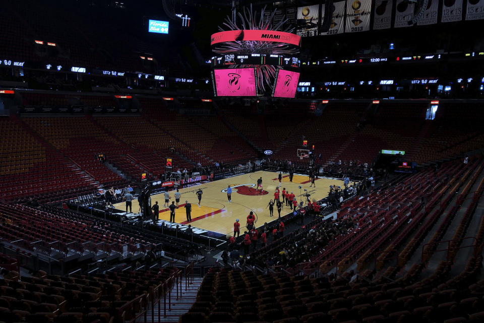 FILE - In this Oct. 23, 2019, file photo, the Miami Heat and the Memphis Grizzlies practice before an NBA basketball game in Miami, Fla. If so inclined, NBA teams like Miami, Orlando and Utah could all be back in the gym for voluntary workouts in small groups starting Friday when the league ban on such things expires. None of them will be reopening that day. There's a clear desire for basketball to resume but, perhaps mindful of how rushing back too quickly hurt other leagues around the world, the NBA seems to be taking very cautious baby steps back to the court. (AP Photo/Brynn Anderson, File)