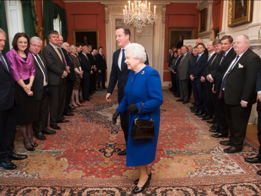 Queen Elizabeth II arrives with British Prime Minister David Cameron to meet members of the cabinet at Number 10 Downing Street as she attends the Government’s weekly Cabinet meeting on December 2012 in London (Getty Images)