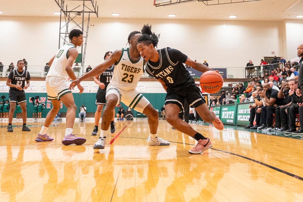 Indianapolis Arsenal Technical High School sophomore Elexander Harris (0) makes a move around the defense of Indianapolis Crispus Attucks High School senior Jacson Payton (23) during the first half of an IHSAA Class 4A Boys’ Sectional basketball game, Wednesday, Feb. 28, 2024, at Lawrence North High School.