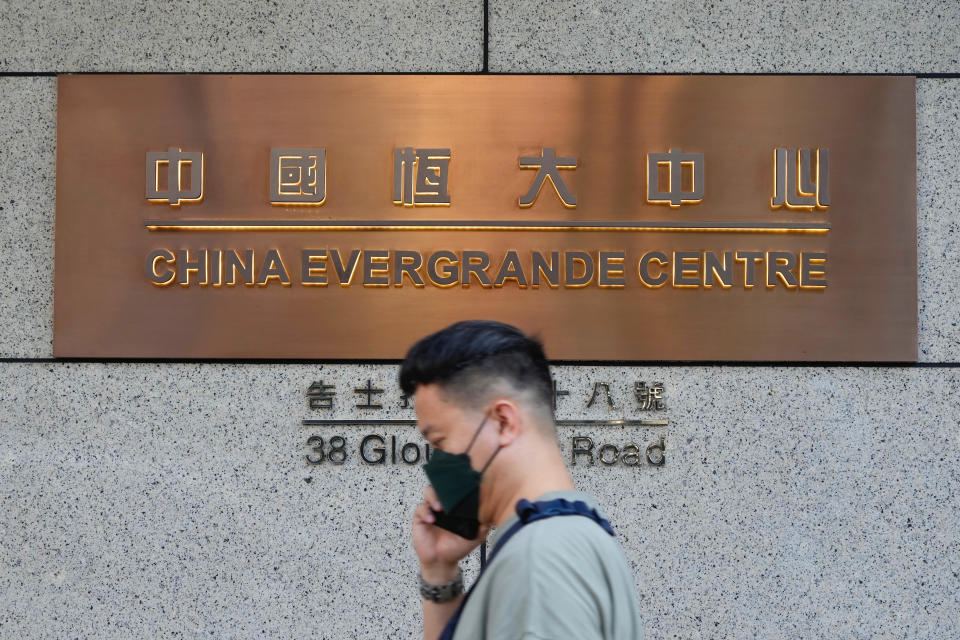 A man walks past the entrance of the headquarters of China Evergrande Group in Hong Kong Monday, Oct. 4, 2021. Shares in troubled real estate developer China Evergrande Group and its property management unit Evergrande Property Services were suspended from trading Monday in Hong Kong. (AP Photo/Vincent Yu)