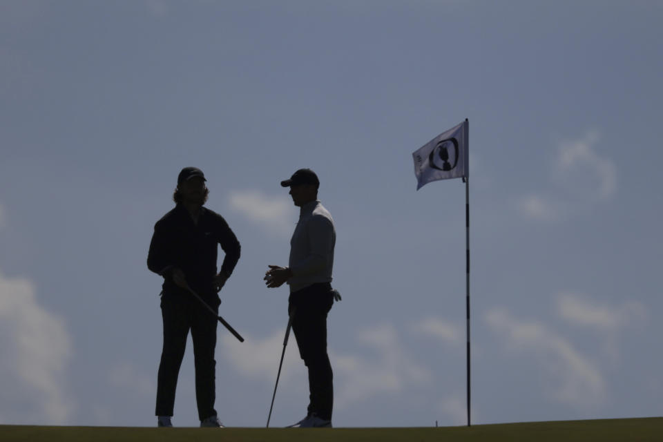 Northern Ireland's Rory McIlroy, right speaks to England's Tommy Fleetwood on the 17th hole during a practice round for the British Open Golf Championships at the Royal Liverpool Golf Club in Hoylake, England, Wednesday, July 19, 2023. The Open starts Thursday, July 20. (AP Photo/Peter Morrison)