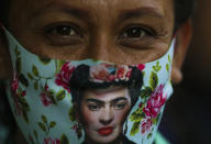 An artisan wearing a face mask decorated with an image of iconic Mexican artist Frida Kahlo attends a protest blocking Paseo de la Reforma avenue in Mexico City, Tuesday, June 16, 2020. Artisan families originally from Oaxaca are asking for financial help, months after the city government closed their market as part of the lockdown to curb the spread of COVID-19. (AP Photo/Fernando Llano)