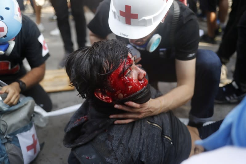 Foto de personal médico atendiendo a un manifestante herido en una marcha en Santiago, Chile