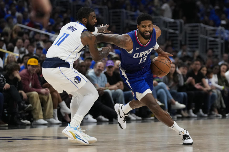 Dallas Mavericks guard Kyrie Irving (11) defends against LA Clippers forward Paul George (13) during the first half of Game 1 of an NBA basketball first-round playoff series in Los Angeles, Sunday, April 21, 2024. (AP Photo/Ashley Landis)