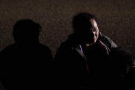 A migrant from Honduras sits in line with others after turning herself in upon crossing the U.S.-Mexico border Monday, May 17, 2021, in La Joya, Texas. The Biden administration has agreed to let up to about 250 people a day in the United States at border crossings with Mexico to seek refuge, part of negotiations to settle a lawsuit over pandemic-related powers that deny migrants a right to apply for asylum, an attorney said Monday. (AP Photo/Gregory Bull)