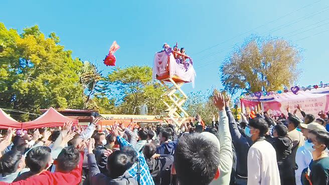 14日大年初五巧逢西洋情人節，嘉義市大福興宮月老祖廟舉辦拋繡球活動，女性在高空車上拋繡球，男性紛紛高舉雙手搶球，場面熱烈。（廖素慧攝）