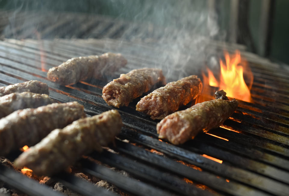 "Mici", the Romanian version of a Turkish dish, spicy grilled sausages, popular across the Balkans, are grilled in a restaurant in Bucharest, Romania, Sunday, Feb. 16, 2014. Officials in Brussels have agreed that spicy “mici", grilled meat bullet shaped delicacies which rely on a pinch of bicarbonate of soda for their distinctive succulent flavor and puffy texture will be permitted under European Union rules, the Romanian Meat Association says.(AP Photo/Octav Ganea/Mediafax) ROMANIA OUT