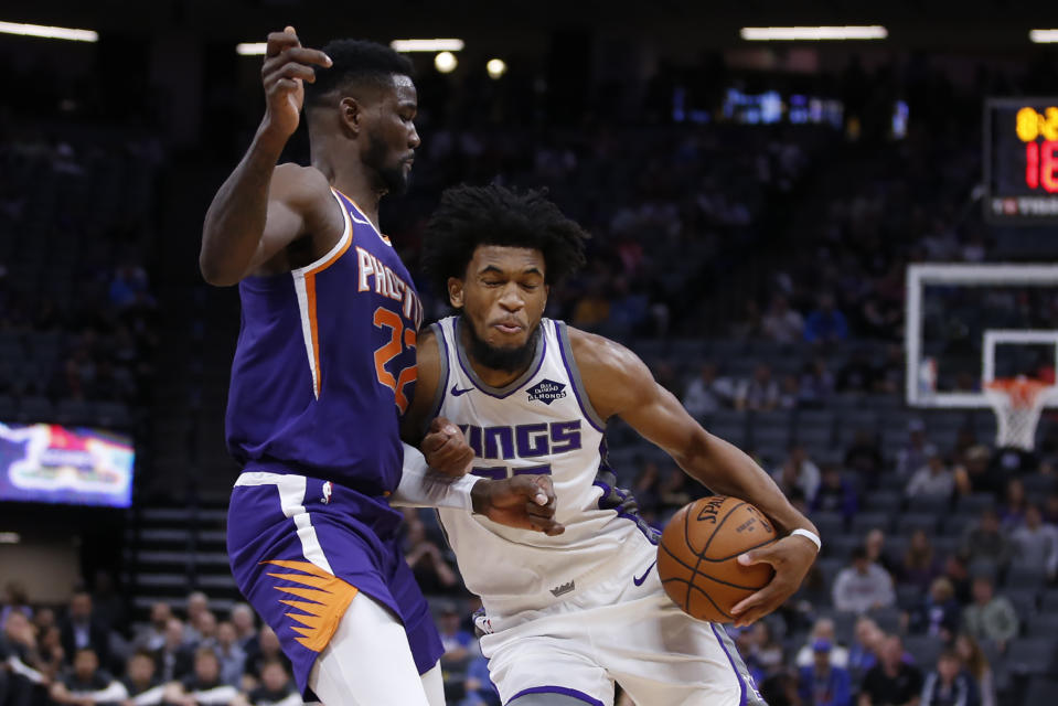 Phoenix Suns center Deandre Ayton, left, blocks he drive of Sacramento Kings forward Marvin Bagley III during the first quarter of an NBA preseason basketball game in Sacramento, Calif., Thursday, Oct. 10, 2019. (AP Photo/Rich Pedroncelli)