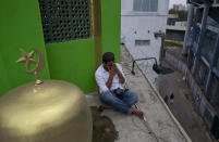 A Muslim volunteer prays perched on the roof of a mosque to spot possible hostile people during Friday prayers in Colombo, Sri Lanka, Friday, April 26, 2019. Hundreds gathered at mosques that conducted Friday prayer services despite warnings of more bomb attacks by Islamic State-claimed militants. And while praying through tears to Allah to help their fellow countrymen, all stressed one thing. The Easter attacks targeting churches and hotels that killed at least 250 people came from people who didn't truly believe the teachings of Islam. (AP Photo/Gemunu Amarasinghe)