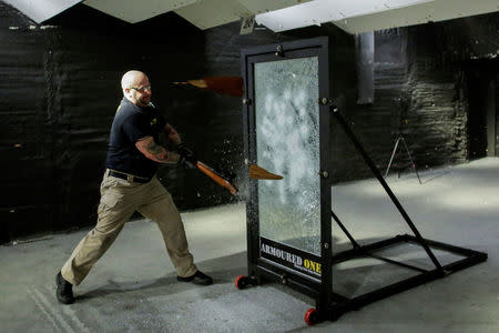 Armoured One CEO Tom Czyz hits with a rifle one of the company's security glass for an active shooter preparedness drill demonstration at Rockland Indoor Shooting, in Pearl River, New York, U.S., December 12, 2017. REUTERS/Eduardo Munoz