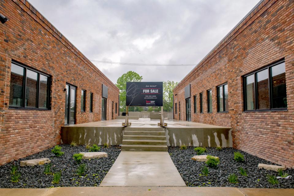 A "For Sale" sign stands between a pair of newly renovated commercial buildings known as the Prospect Mall at 4615 Prospect Road in Peoria Heights.