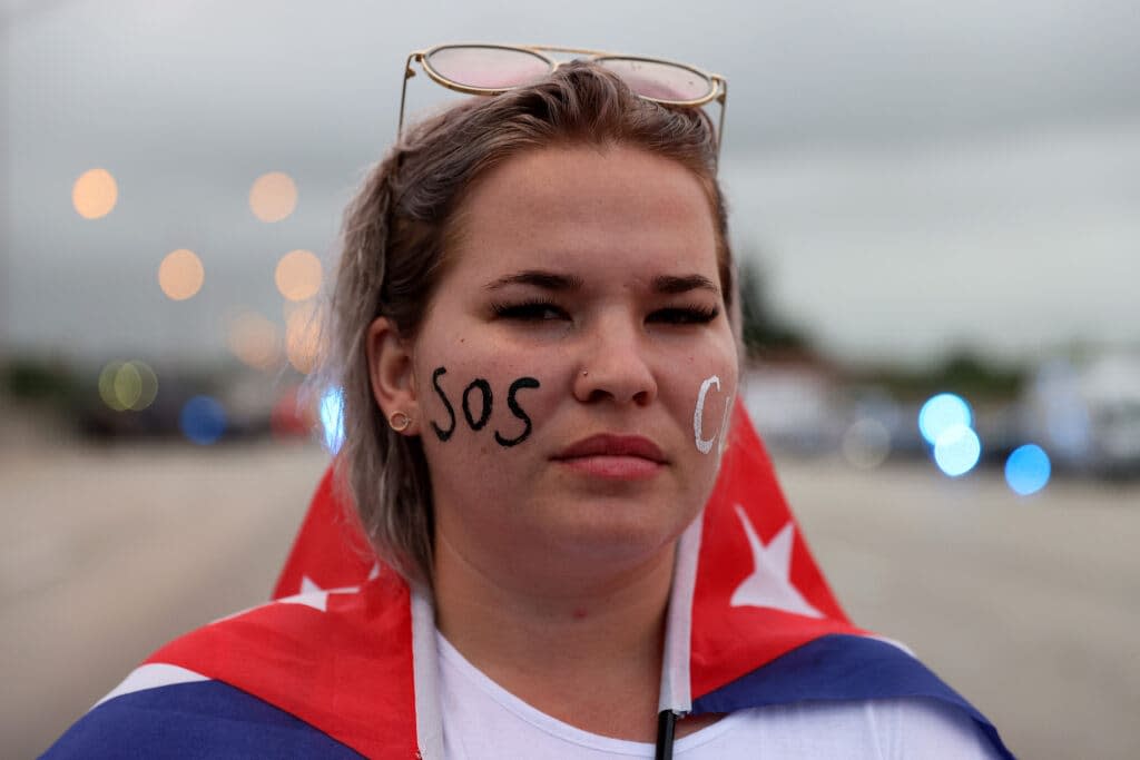 Anabel Alcaz joins with other protesters who shut down part of the Palmetto Expressway as they show their support for the people in Cuba July 13, 2021 in Miami, Florida. (Photo by Joe Raedle/Getty Images)