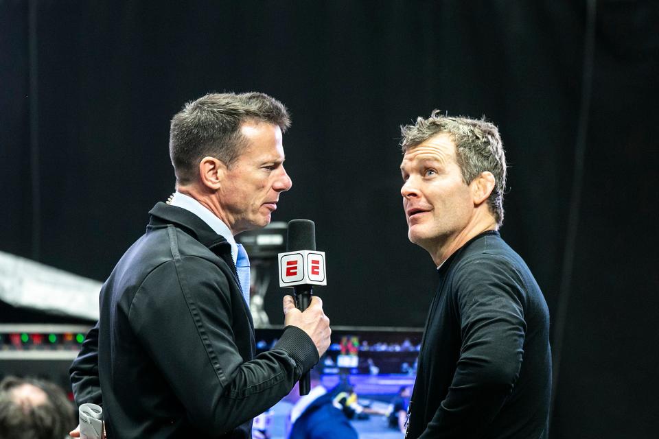 Iowa head coach Tom Brands, right, looks up into the crowd while being interviewed during the fifth session of the NCAA Division I Wrestling Championships, Saturday, March 19, 2022, at Little Caesars Arena in Detroit, Mich.