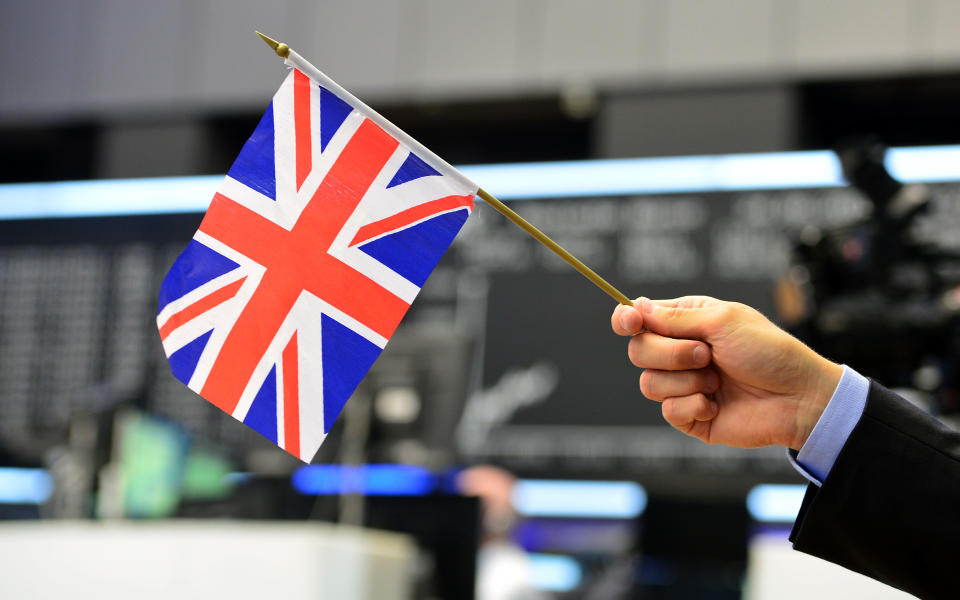 FRANKFURT AM MAIN, GERMANY - JUNE 24: A TV reporter pose with a Great Britain flag at the Frankfurt Stock exchange the day after a majority of the British population voted for leaving the European Union on June 24, 2016 in Frankfurt am Main, Germany. Many prominent corporate CEOs and leading economists have warned that a Brexit would have strongly negative consequences for the British economy and repercussions across Europe as well. (Photo by Thomas Lohnes/Getty Images)